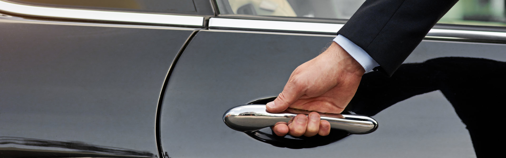 Hand of male person on vehicle handle in professional transport service